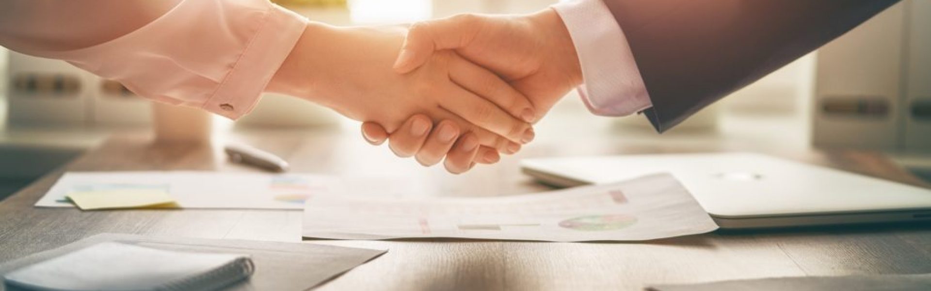 Man and woman are shaking hands in office. Collaborative teamwork.